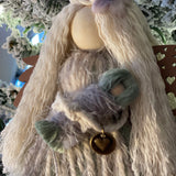 This image shows the agnel close up holding her baby with the heart metal charm embellishment.