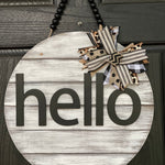 Hello Door Hanger is shown hanging on a front door.  This is the white distressed hanger with black beaded garland.