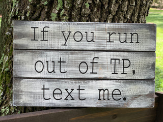 If you run out of TP, text me, is shown sitting on a ladder outside.  This is a rustic stained pallet board sign distressed with white paint.  Sits on a shelf or any flat surface.