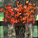 Bittersweet Floral Glass Vase shows an image of two vases together.  Each vase has tricolored earth tone rocks and tan moss with orange bittersweet artificial floral decor. Each sold separately.  