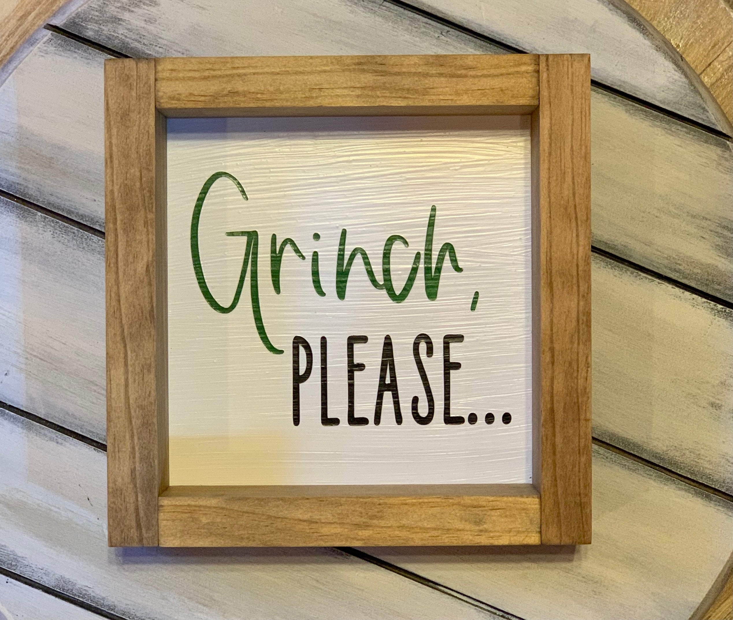 Grinch, Please 7x7 Frame is shown by itself.  The shadowbox frame is a neutral stain with hand painted green Grinch lettering and black please lettering. 
