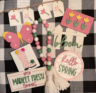 This set includes 1 tulip banner, 1 tulip mini 3D sign, 1 3D mini butterfly, 1 3D fence cutout that says bloom, 1 mini round shiplap sign that says hello Spring, 1 mini market fresh flower sign, 1 mini 3D rain boot sign with flowers, and 1 25" wood bead garland.