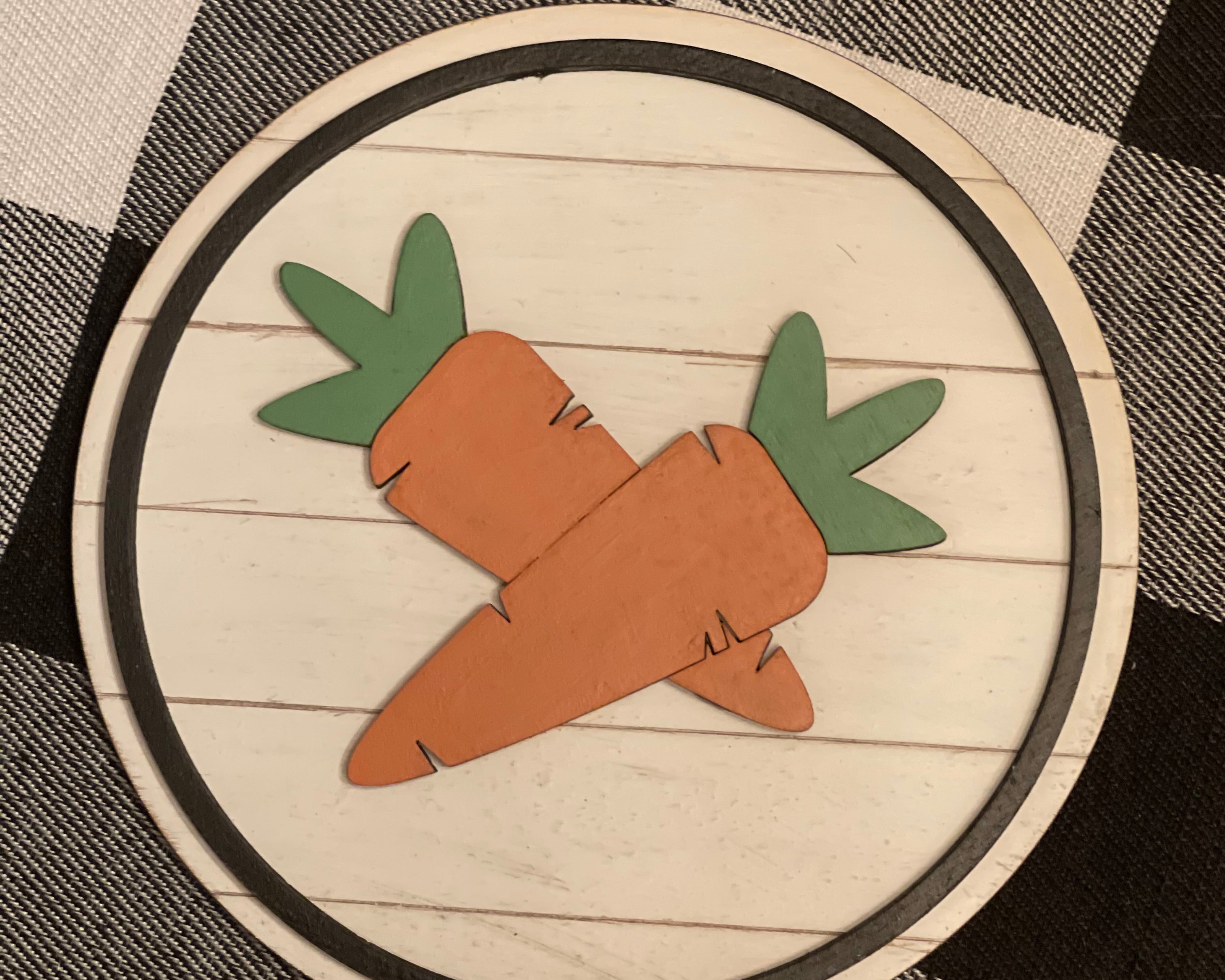 This 5x5" round shiplap sign shows 3D carrots attached with a black wood boarder.  