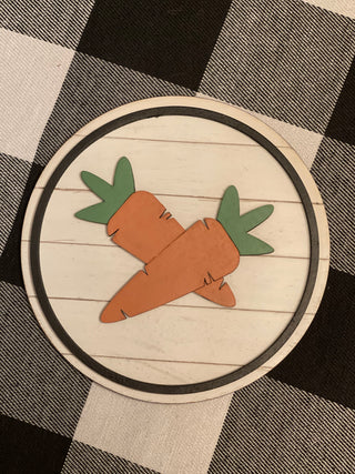This 5x5" round shiplap sign shows 3D carrots attached with a black wood boarder.  