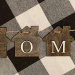 This image show a close up of the home banner.  Jacobean stained wood house cutouts with the letters HOME added to each house.  The banner is 32" from end to end. 