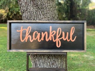Metallic Thankful Sign shows an image of the sign sitting on a ladder outside.