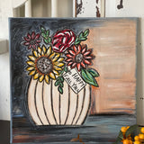 This image shows the hand painted sign displayed on a bench with fall floral flowers.