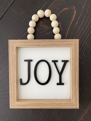 This image displays the JOY sign on a bench.