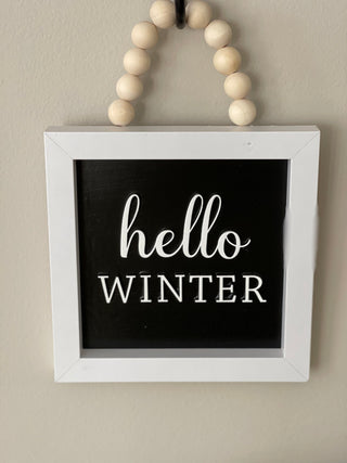 This image shows the hello winter hanging on a hook.