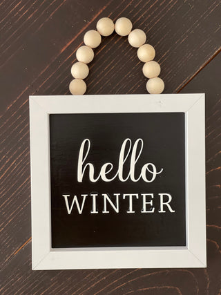 This image displays the hello winter on a bench.
