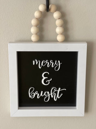This image shows the merry and bright hanging on a hook.