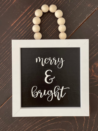 This image shows the merry and bright displayed on a bench.