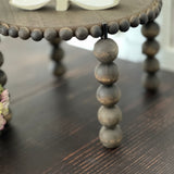 This image shows the close up beads on the legs of the stand and the top.