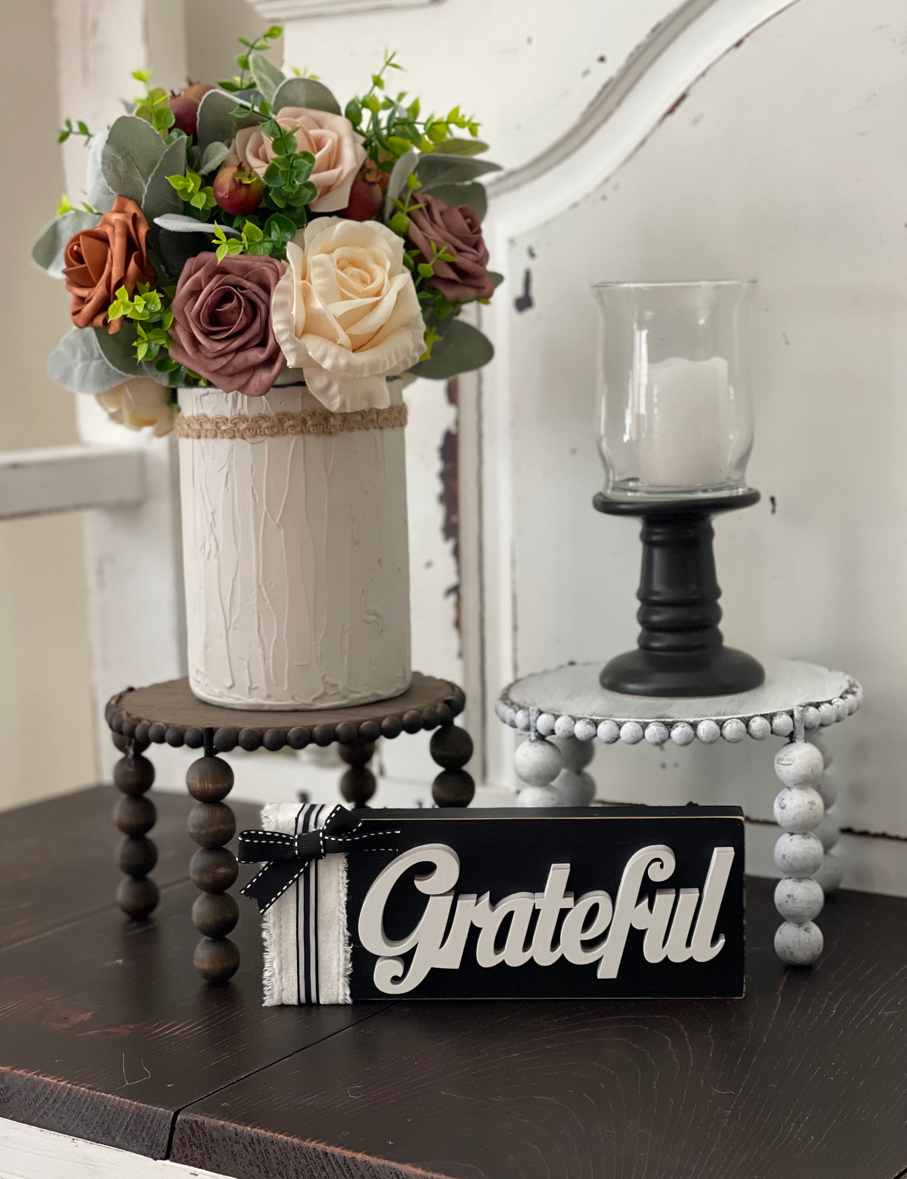 This image shows the paired Jacobean and distressed white risers on a bench with a floral arrangement, candle and a grateful sign. Each item sold separately.