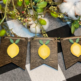 Lemon 3D Banner is shown laying on a table with floral and cotton embellishments.