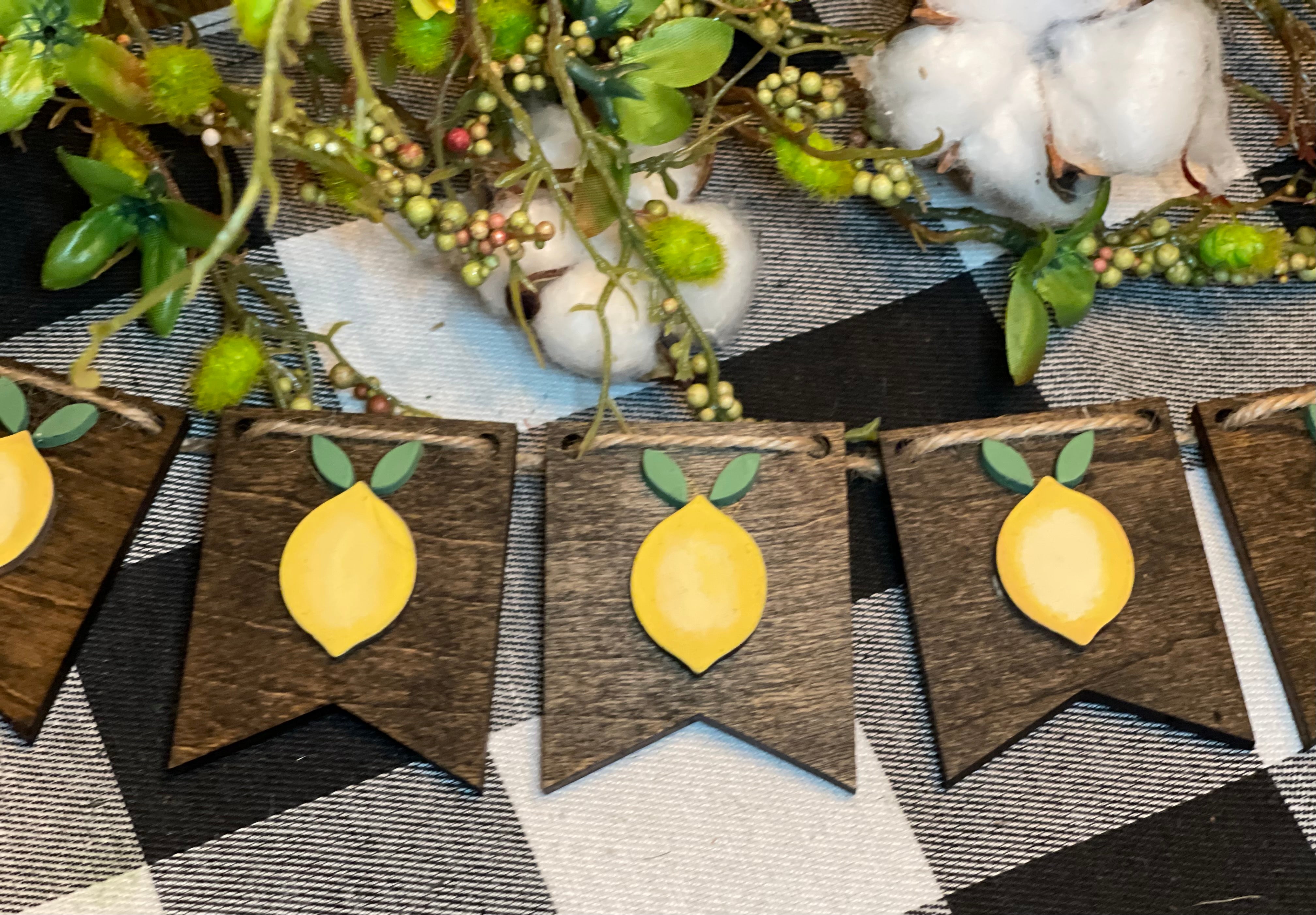 Lemon 3D Banner is shown laying on a table with floral and cotton embellishments.