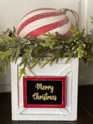 This image shows the Merry Christmas Ornament Box with red and white glitter ornament and pine greenery.
