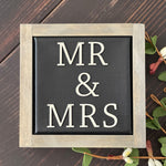 Mr + Mrs mini canvas sign is shown displayed on a bench with a floral design.