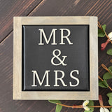 Mr + Mrs mini canvas sign is shown displayed on a bench with a floral design.