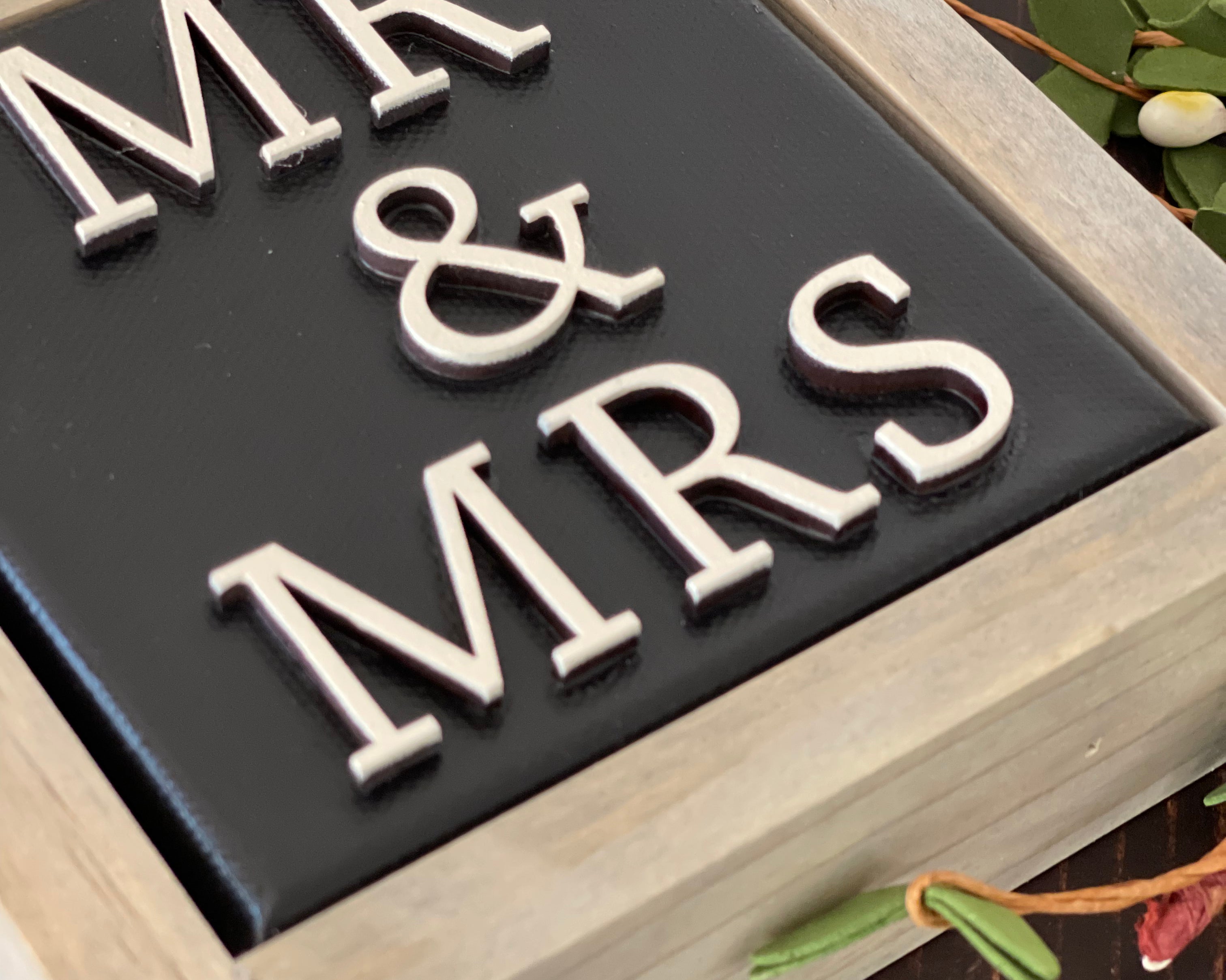 This image is a close up of the 3D lettering.This sign is black with white lettering.