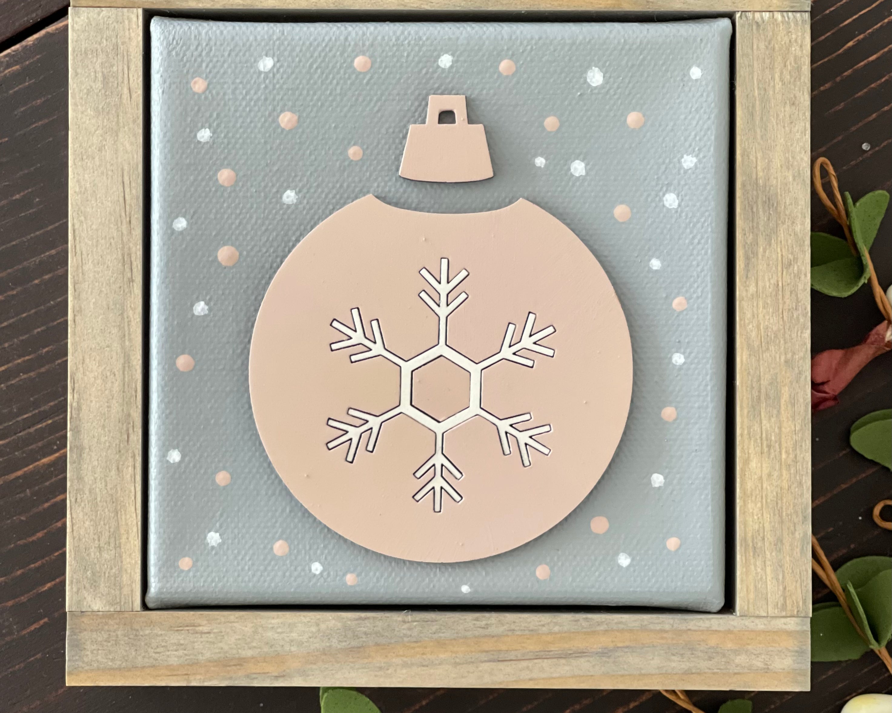 This is an image showing the pink and white 3D ornament canvas sign sitting on a bench.