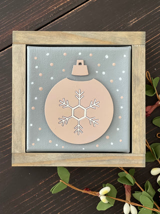 This is an image showing the pink and white 3D ornament canvas sign sitting on a bench.