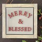 Merry + blessed is displayed on a bench with greenery.