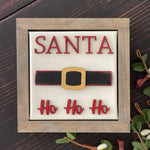 This image shows the santa sign with wood cutouts and a wood stained frame.