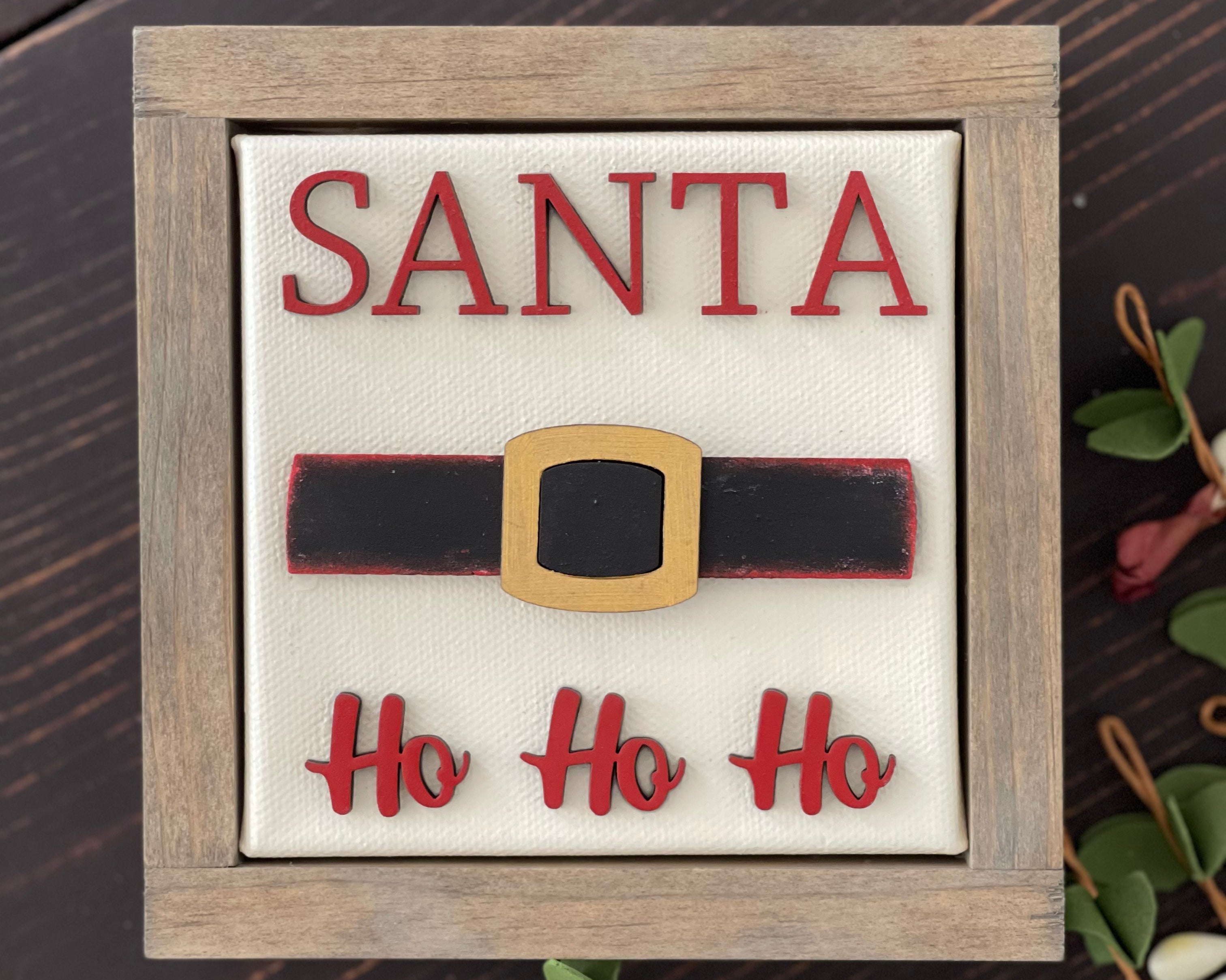 This image shows the santa sign with wood cutouts and a wood stained frame.