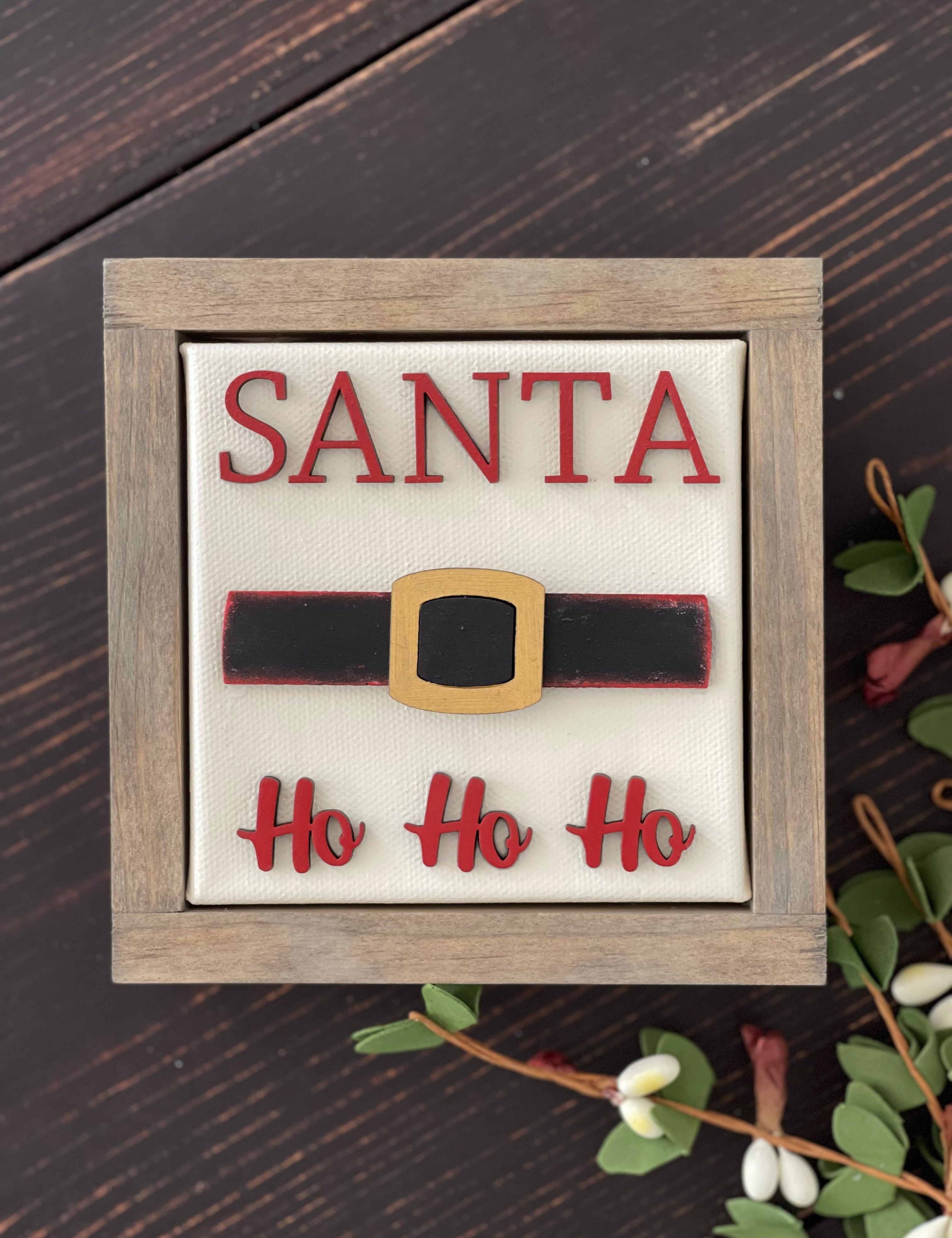 This image shows the santa sign with wood cutouts and a wood stained frame.