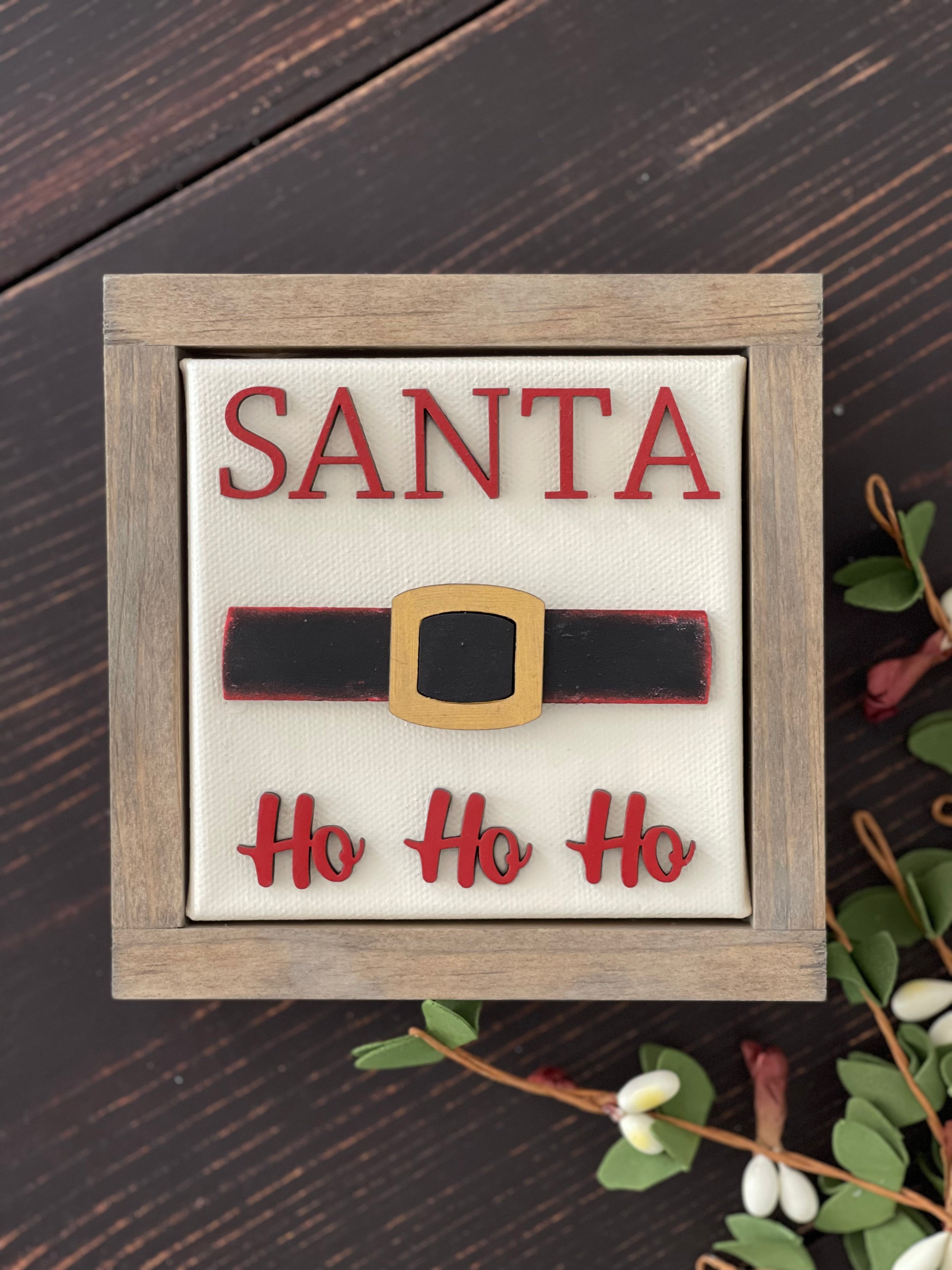 This image shows the santa sign with wood cutouts and a wood stained frame.