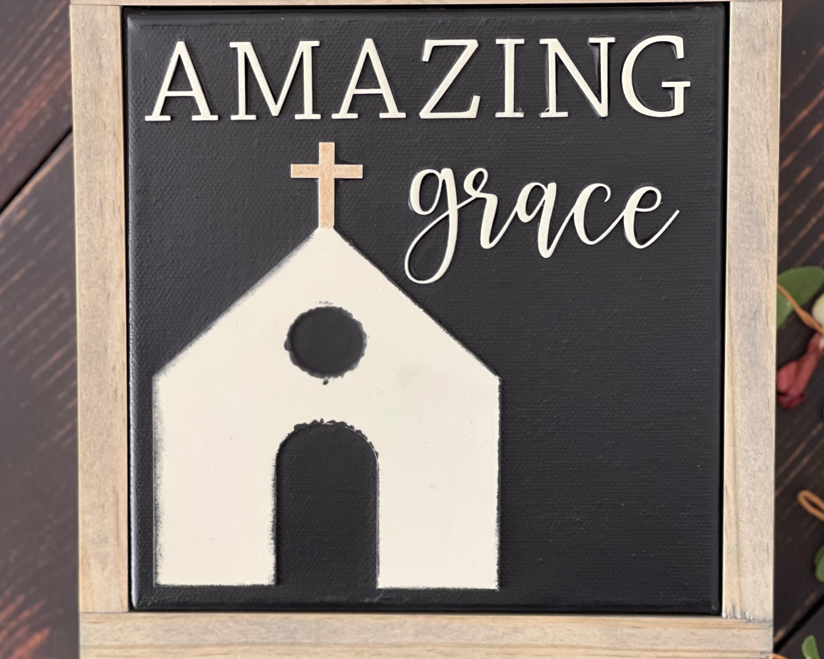 This image shows the sign Amazing Grace with a church, all in 3D cutouts.  A stained frame has been added to the canvas sign.
