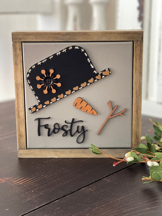 This image shows the Frosty sign standing up on a bench.