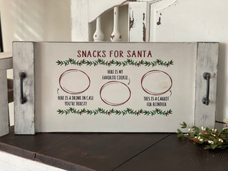 This beautiful distress Santa snack tray is displayed on a bench with greenery.
