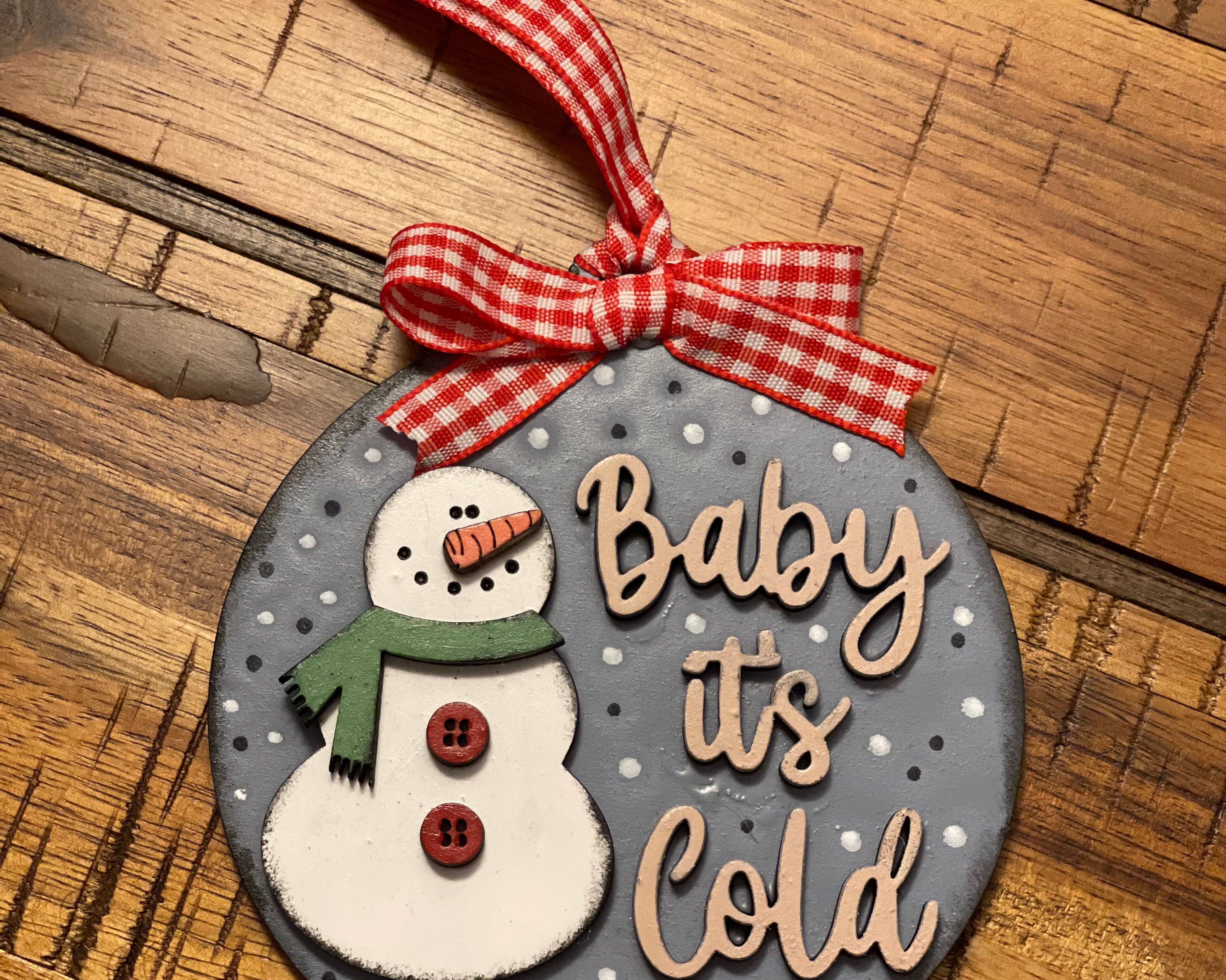 This ornament is shown laying on a wood table.