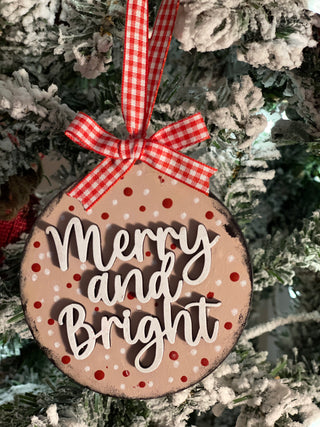 Merry and Bright ornament is show displayed hanging on a Christmas tree.