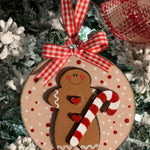 The gingerbread ornament is shown hanging on a tree,