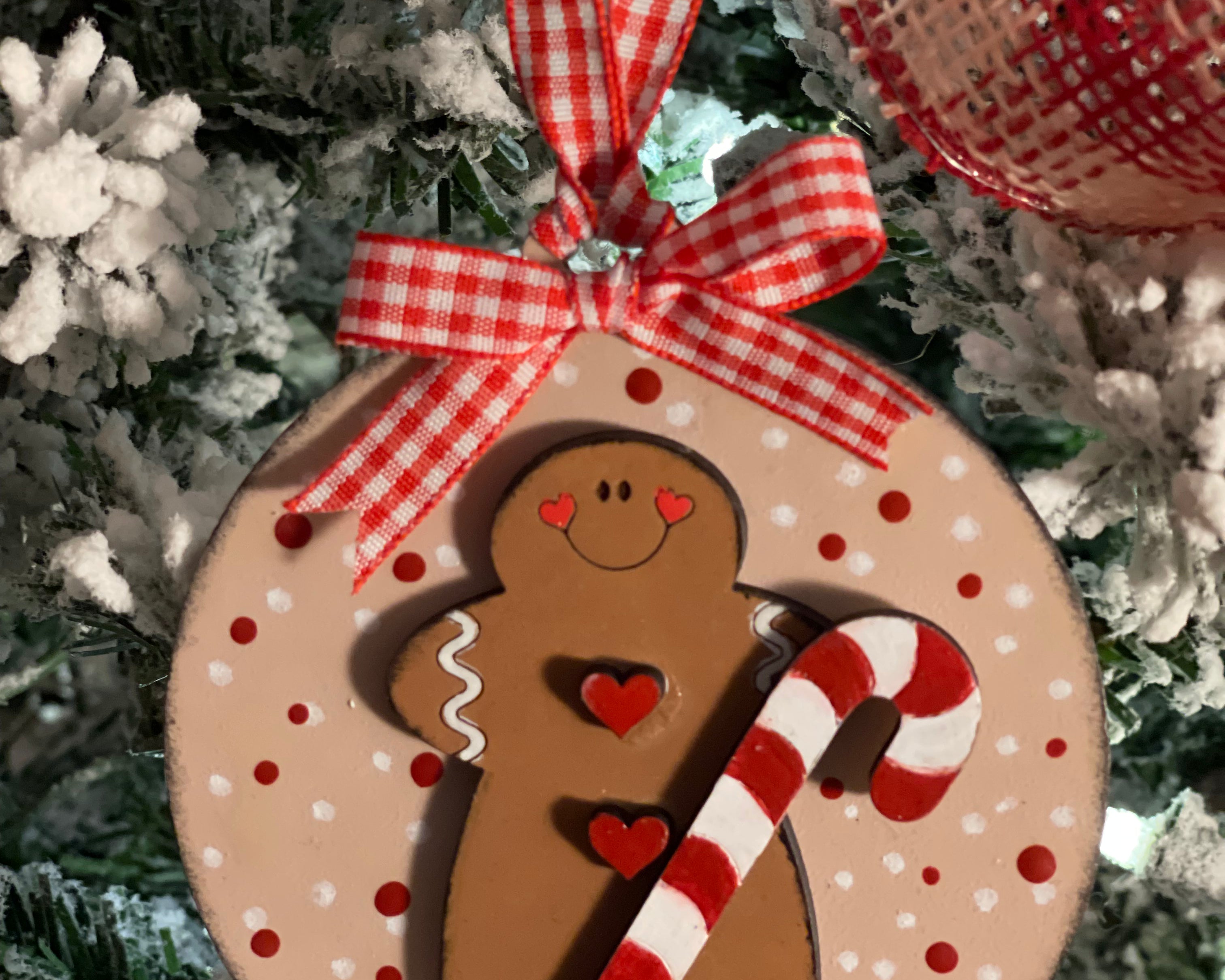 The gingerbread ornament is shown hanging on a tree,