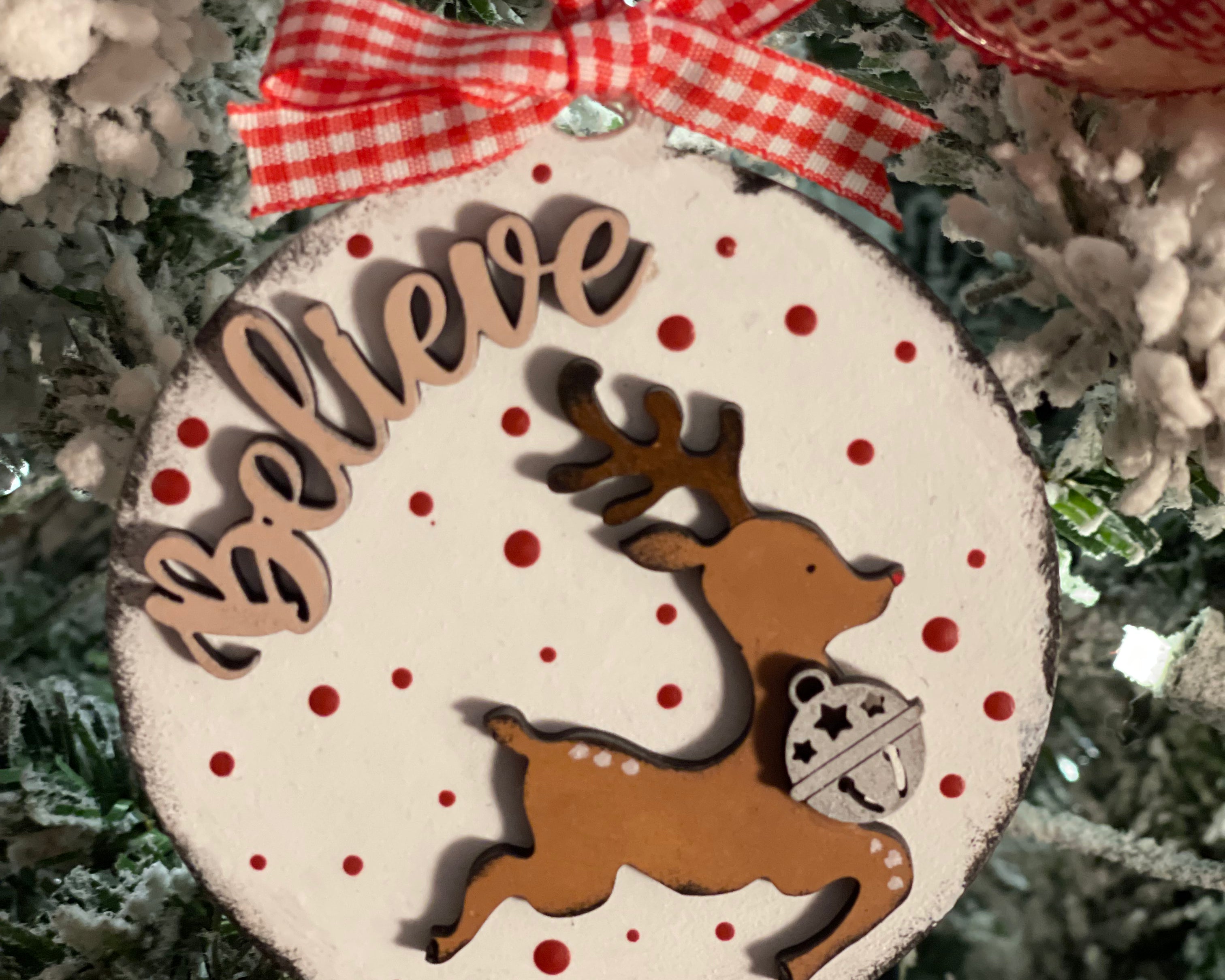 The ornament is displayed hanging on a tree