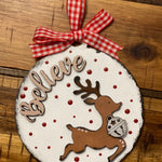 The ornament is shown displayed on a wood table.