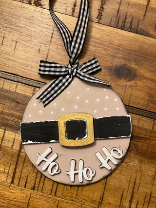 The pink ornament is shown on a wood table.