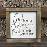Good Friends Offer Advice, But Real Friends Offer Wine (Script Version) shows the sign sitting outside on a ladder.