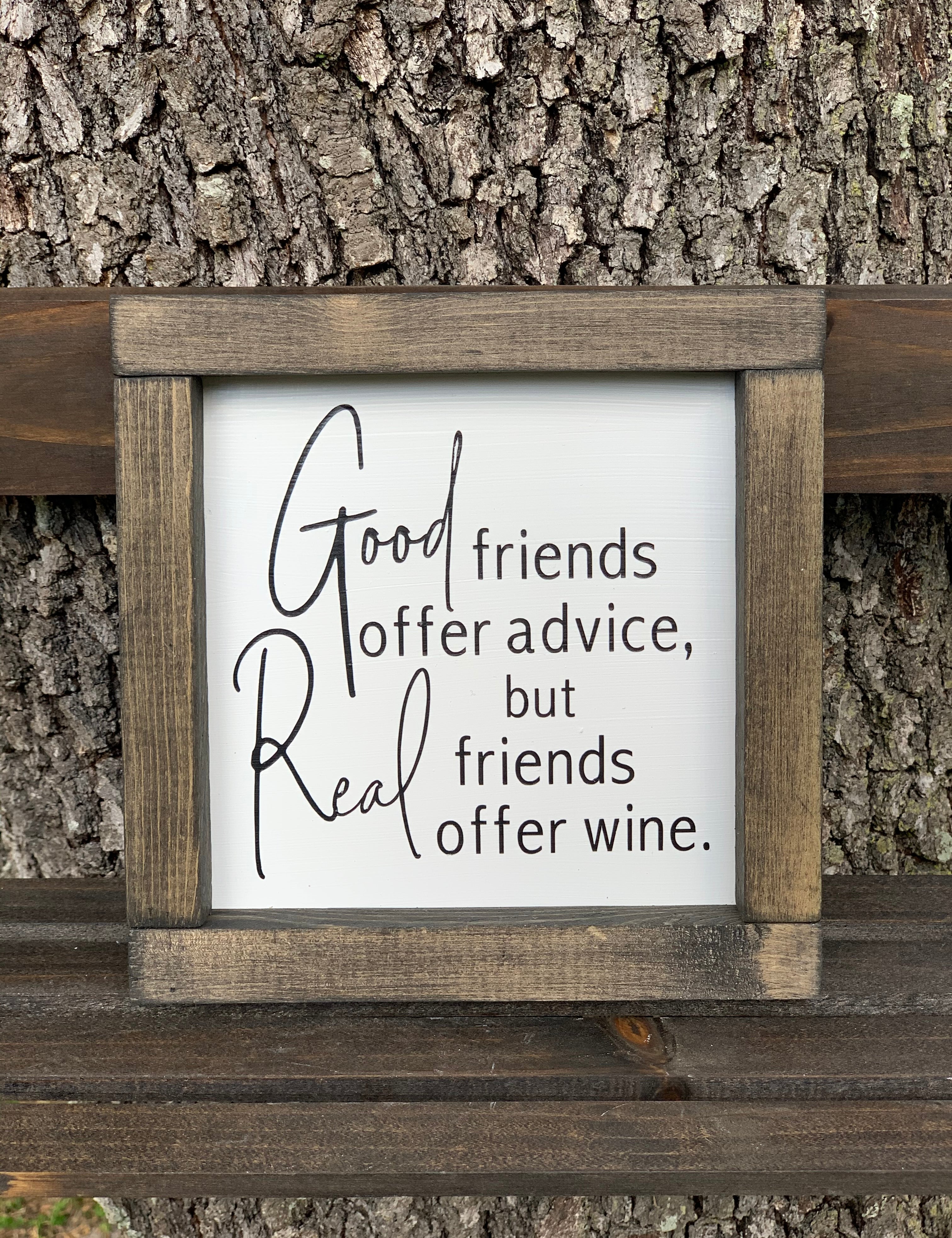 Good Friends Offer Advice, But Real Friends Offer Wine (Script Version) shows the sign sitting outside on a ladder.