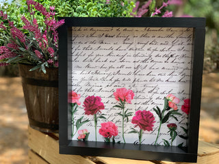 The Vintage Letter is shown sitting outside beside a floral arrangement.