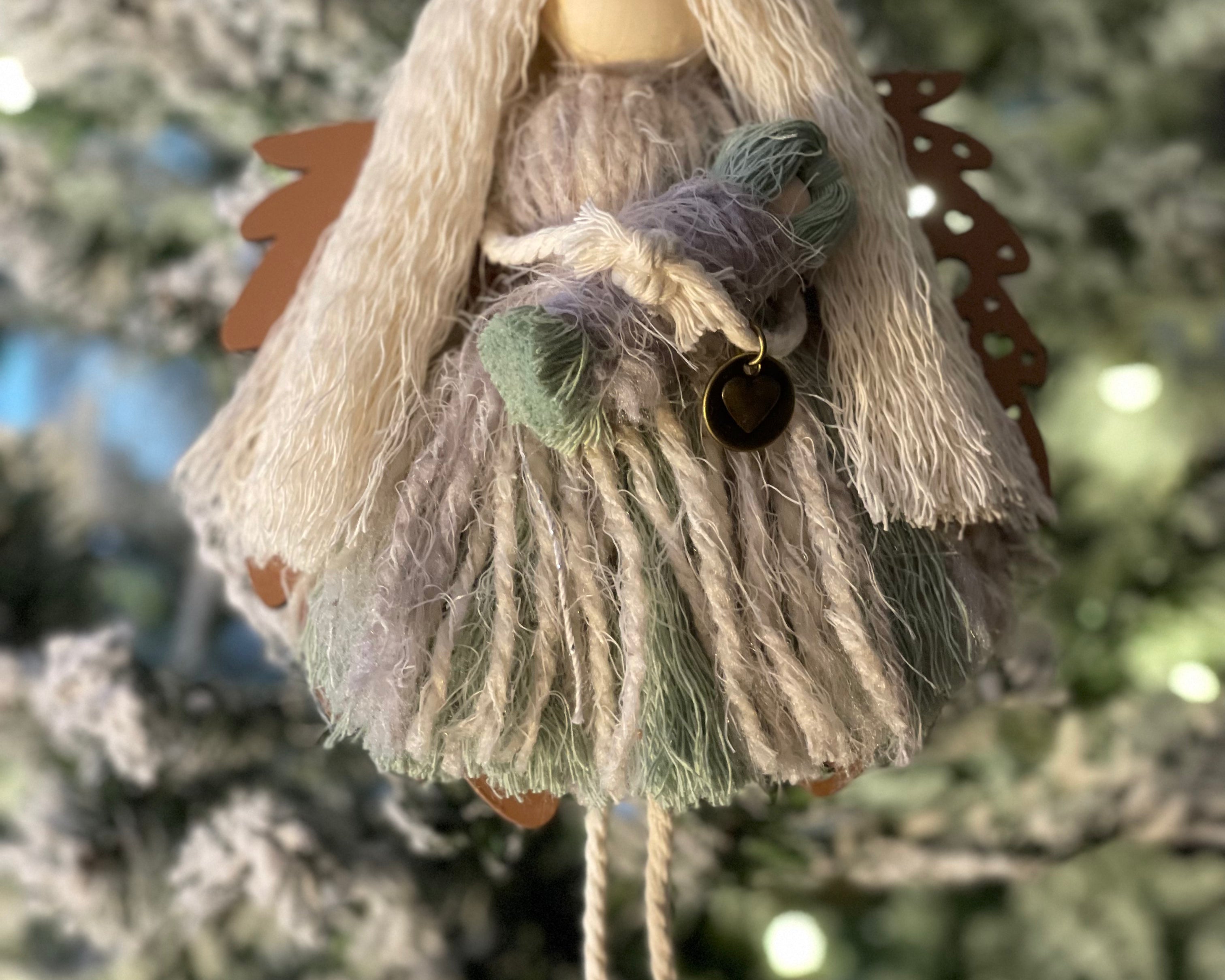 This is the sage macrame angel with blonde hair holding her baby with the walnut wood angel wings.