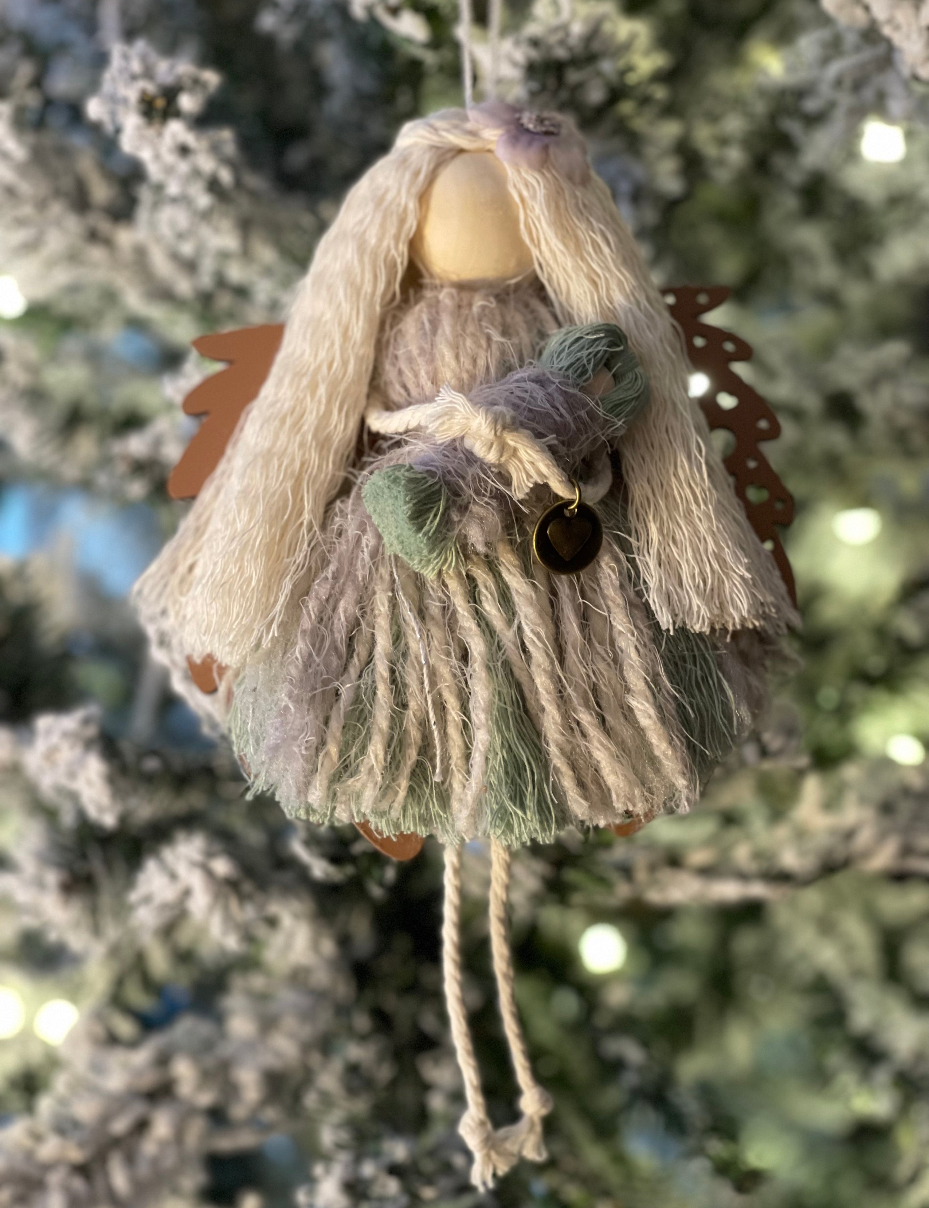 This is the sage macrame angel with blonde hair holding her baby with the walnut wood angel wings.