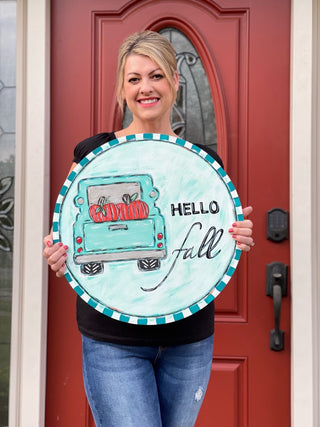 This image shows the DIY made into a door hanger on a 19.5 inch wood round.  