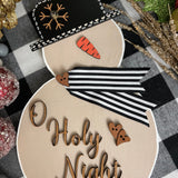 This image shows the large tan snowman with the saying O Holy Night.