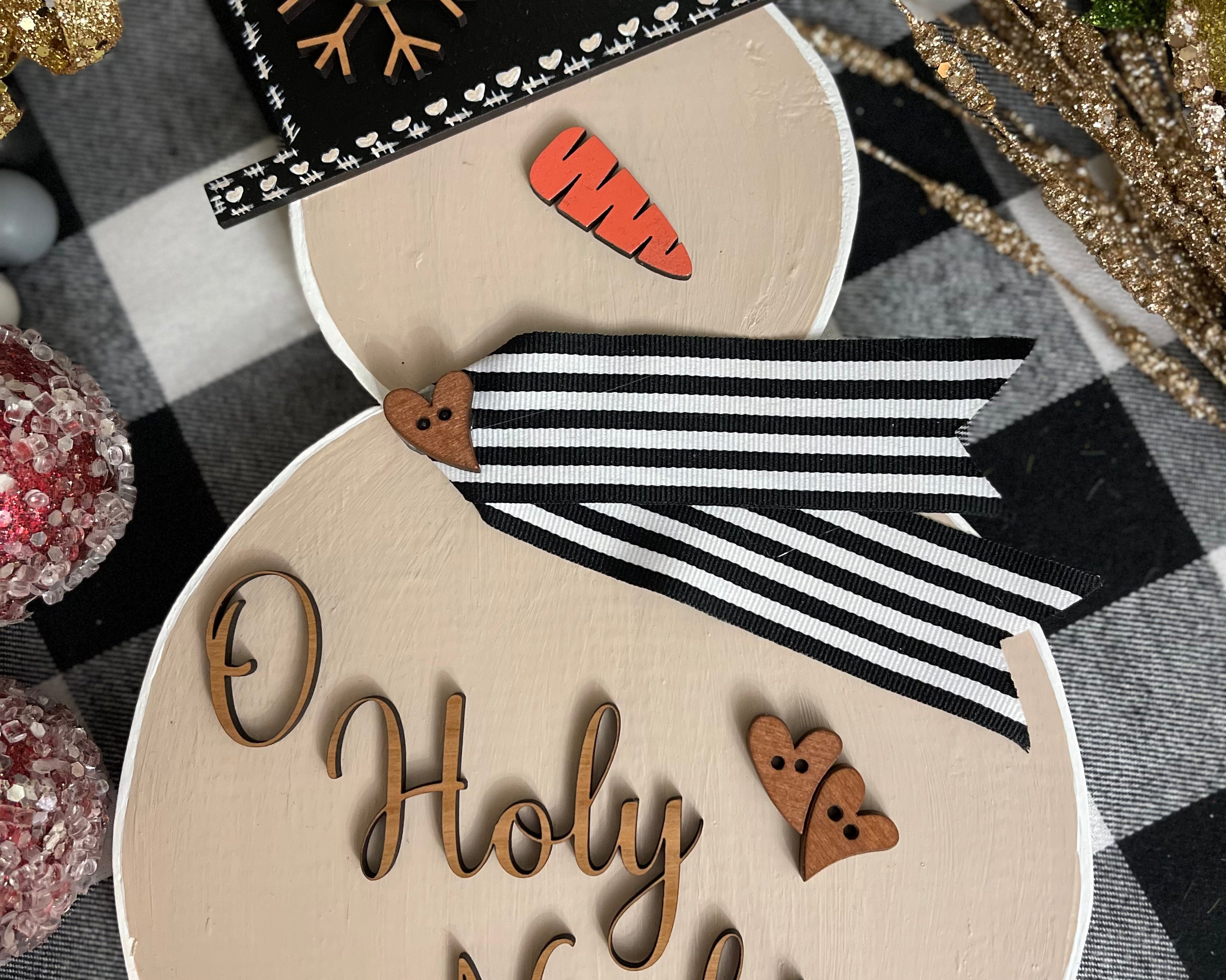 This image shows the large tan snowman with the saying O Holy Night.