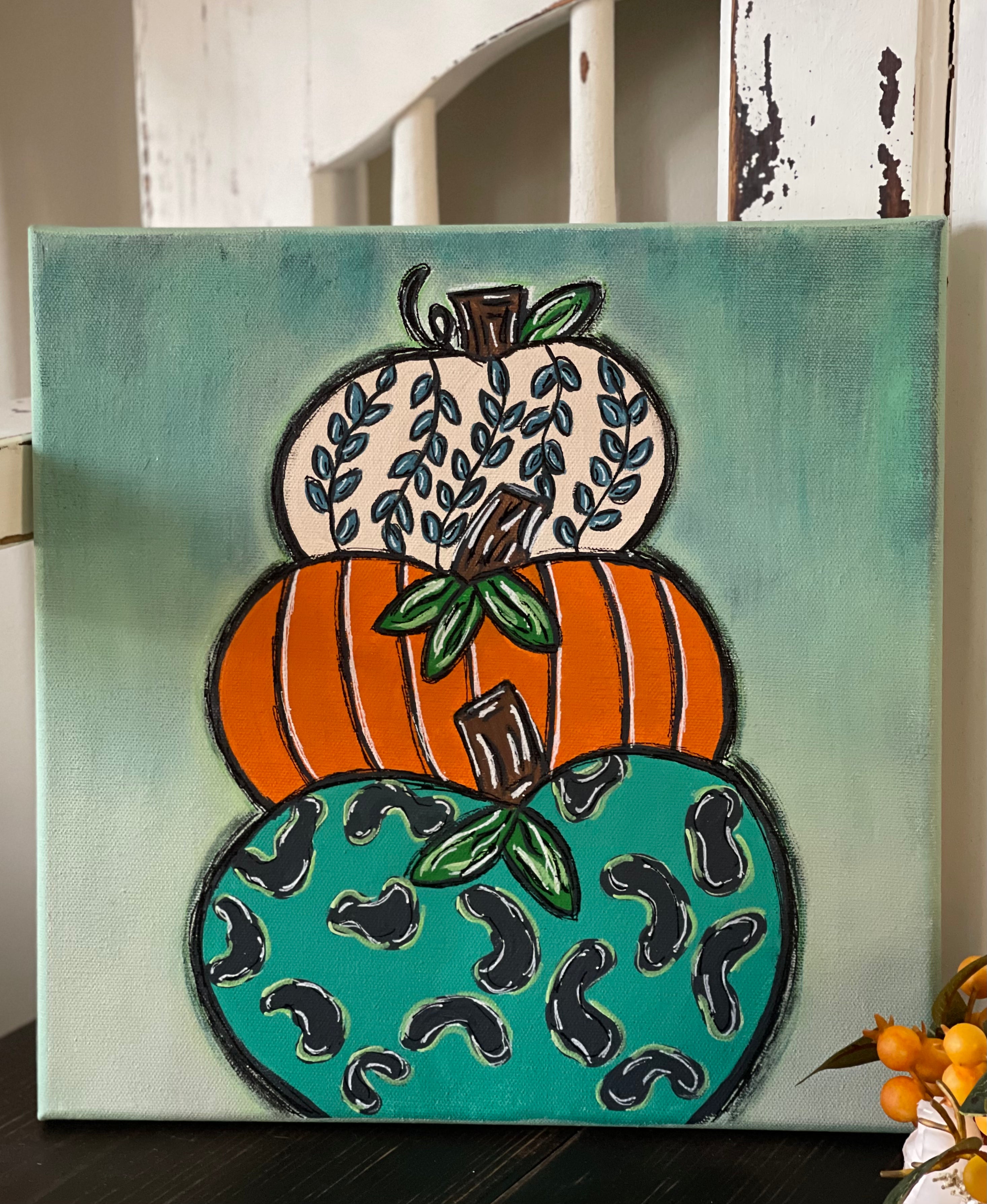 This image shows the final DIY painted design of the pumpkin trio, 